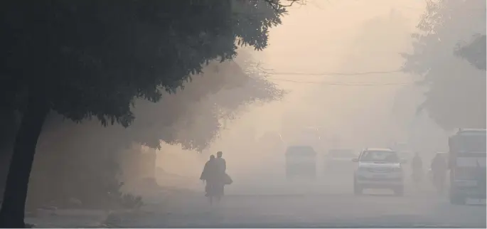  ?? Picture: AFP ?? People walk amid heavy smog on Thursday, a day after Gurgaon in India was placed top of a report on the world’s most polluted cities for 2018. India dominated the list, taking 22 of the top 30 spots, according to a Greenpeace report, with Gurgaon topping the list.