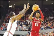  ?? AP PHOTO/BUTCH DILL ?? Alabama forward Brandon Miller (24) shoots over Auburn forward Jaylin Williams on Saturday during the first half of an NCAA college basketball game in Auburn, Ala.