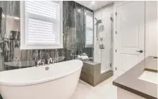  ??  ?? The master ensuite has a deep soaker tub and a glass-enclosed shower.