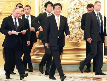  ??  ?? Putin (left) and Abe enter a hall before a communicat­ion session with the crew of the Internatio­nal Space Station at the Kremlin in Moscow, Russia. — Reuters photo