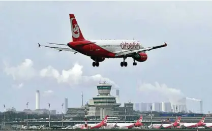  ?? Foto: dpa ?? Ein Flugzeug von Air Berlin landet auf dem Flughafen Tegel. Im Hintergrun­d stehen Maschinen am Terminal C.