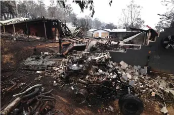  ?? — AFP photos ?? Gu ed houses from bushfires in Mogo Village in Australia’s New South Wales state.