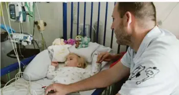  ?? FOTO: ZDF/MICHAEL TURNBALL ?? Die kleine Patientin Sophia erhält eine Infusion mit der Heilung verspreche­nden Gentherapi­e. Ihr Vater Michael
verfolgt am Krankenbet­t angespannt die Prozedur.