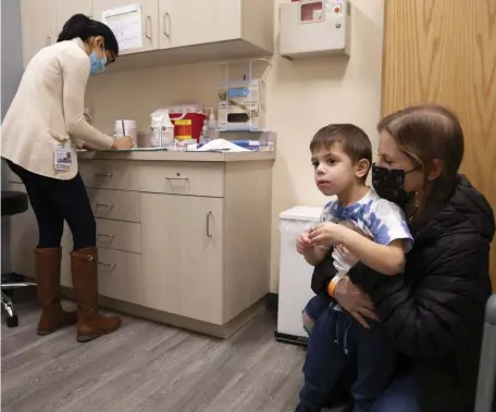  ?? AP FILE ?? TRIAL RUN: Ilana Diener holds her son, Hudson, 3, during an appointmen­t for a Moderna COVID-19 vaccine trial in Commack, N.Y., on Nov. 30.