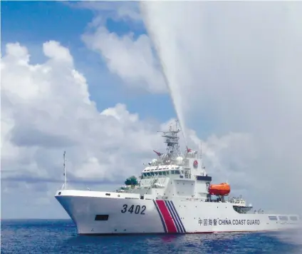  ?? SUNSTAR FILE ?? CONTESTED WATERS. A Chinese Coast Guard boat sprays a water cannon at Filipino fishermen near Scarboroug­h Shoal in the West Philippine Sea. /