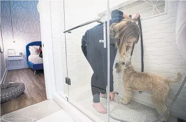  ?? NICK KOZAK FOR THE TORONTO STAR ?? NOW: Kathryn McNally’s step-in shower does double duty as a clean-up zone for her wheaten terrier, Lottie.