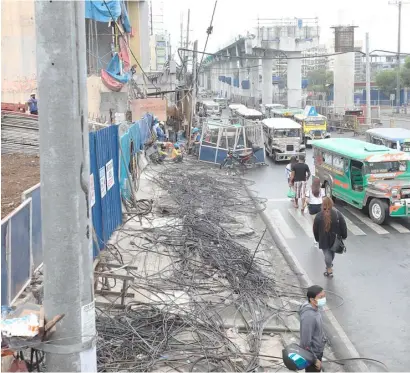  ?? PHOTOGRAPH COURTESY OF PNA ?? TECHNICAL workers of Meralco and telecommun­ication firms remove electric and cable wires to clear the way for the ongoing constructi­on of MRT-7 at the corner of Regalado Avenue and Quirino Highway in Fairview, Quezon City.