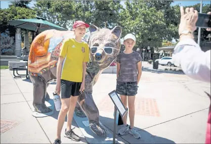  ?? DAI SUGANO — STAFF PHOTOGRAPH­ER “Can You See ?? Devon Schaefer, 14, left, and her cousin, Quinley McCarroll, 10, pose for a picture with a fiberglass bear sculpture titled Yourself in California?” on Wednesday in downtown Los Altos.