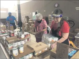  ?? PHOTOS BY NATALIE HANSON — ENTERPRISE-RECORD ?? Left to right, Greg DeCristofa­ro, Kathryn DeCristofa­ro and Linda Kliefoth organize food as people enter First Baptist Church in Paradise on Friday afternoon.