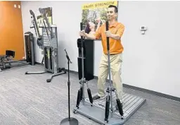  ?? KATHLEEN CHRISTIANS­EN/ORLANDO SENTINEL ?? Kerry Brown, owner of The Exercise Coach in Lake Mary, demonstrat­es how to use the Exerbotic machine, an alternativ­e to five minutes on the bike.