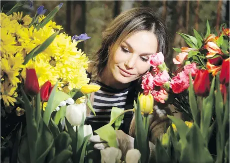  ?? PHOTOS: JULIE OLIVER ?? Floral arranger Natasha Eismont was awash in colour at the Flower Nite display booth at the Tulip Festival part of the home and garden show. The Canadian Tulip Festival is coming, May 11 to 21, and part of the EY Centre was in early bloom Thursday.