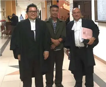  ??  ?? Bukhari (centre), flanked by his lawyers Steven (left) and Gerald, walks out of the courtroom.