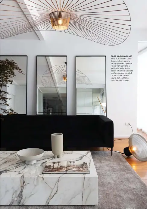  ??  ?? GOOD-LOOKING GLASS A trio of mirrors by Lume Design reflects a grand Vertigo pendant by Petite Friture from ECC and a Muffins lamp by Brokis, beside which is a Cascade rug from Source Mondial. On the coffee table is a Luna dish and Pillars vase from BoConcept.
