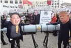  ??  ?? Activists wear masks of world leaders, including North Korea’s Kim Jong Un and President Trump, during a march against nuclear weapons Saturday in Berlin. ADAM BERRY/GETTY IMAGES