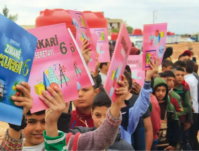  ?? © ANHA ?? Distributi­on de manuels scolaires dans le camp de réfugiés de Shihba, près d’afryn, en avril 2018.