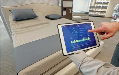  ?? AP ?? A Sleep Number store manager demonstrat­es how the company’s sleep technology tracks your sleeping patterns. —