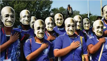  ?? — ABHIJIT MUKHERJEE ?? Youth, wearing masks of Mahatma Gandhi, pose for a photograph during his 149th birth anniversar­y celebratio­ns in Kolkata on Tuesday.