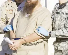  ?? — AFP photo ?? File photo shows a detainee being escorted by military guards from his annual Admistrati­ve Review Board hearing at the US Naval base at Guantanamo Bay, Cuba.