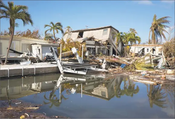  ?? KEVIN HAGEN / NYT ?? Damage to houses and docks in the Florida Keys after Hurricane Irma, in Big Pine Key, Fla., Sept. 14. Despite bigger storms and rising seas, Florida’s land rush continues.