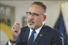  ?? AP file photo ?? Education Secretary Miguel Cardona speaks during an interview with The Associated Press in his office at the Department of Education, Sept. 20 in Washington. A new federal rule threatens to cut federal money to college programs that consistent­ly leave graduates with low pay or unaffordab­le debt.