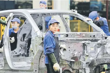  ??  ?? A worker looks on at a BYD assembly line in Shenzhen. China’s new-energy auto firms saw shares surge in Monday morning trade, extending recent strong gains, after a government official said over the weekend that China had begun looking at a ban on...