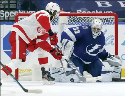  ?? MIKE CARLSON PHOTOS — THE ASSOCIATED PRESS ?? Detroit Red Wings’ Michael Rasmussen, left, scores past Tampa Bay Lightning goaltender Christophe­r Gibson during Sunday’s 5-1victory in Tampa, Fla. It was the Red Wings first road win against the Lightning since Feb. 17, 2011, a losing streak of 17games overall.