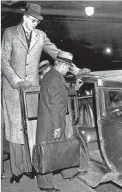  ?? CHICAGO TRIBUNE HISTORICAL PHOTO ?? Wadlow, then 17, holds open the door of a taxicab for his father at Union Station after their arrival in Chicago on Jan. 5, 1936. The two were going to the National Shoe Fair at the Palmer House Hotel.