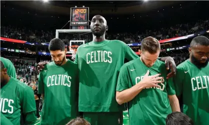  ??  ?? Boston’s Tacko Fall stands with his teammates for the national anthem before a preseason game against the Charlotte Hornets earlier this month. Photograph: Brian Babineau/NBAE via Getty Images