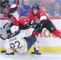  ??  ?? Buffalo’s Johan Larsson gets slammed to the ice by Chris Neil as Sens captain Erik Karlsson stays on the puck against the Sabres.