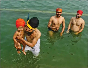  ?? PHOTO: ABHISHEK SHUKLA ?? Devotees take a holy dip at Gurudwara Bangla Sahib on the occasion of Guruparab in New Delhi, on Saturday.