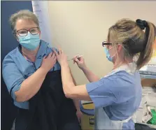  ??  ?? A member of the NHS Ayrshire and Arran staff gets the coronaviru­s vaccine on the mainland.