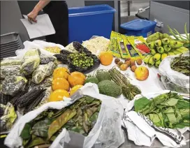  ?? ALYSSA POINTER / ALYSSA.POINTER@AJC.COM ?? Fruits and vegetables seized by Customs officials sit in an inspection area Wednesday at Hartsfield-Jackson Internatio­nal Airport.