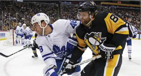  ?? GENE J. PUSKAR/THE ASSOCIATED PRESS ?? Leafs defenceman Roman Polak and former teammate Phil Kessel of the Penguins battle along the boards in the second period of Saturday night’s game.