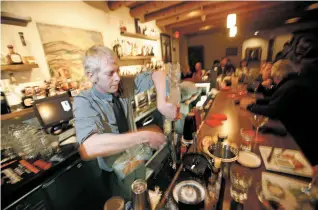  ?? LUIS SÁNCHEZ SATURNO THE NEW MEXICAN ?? Andrew Roy of Santa Fe, bartender and sommelier at El Farol, mixes drinks for patrons Friday. Roy expects a busy shift tonight. ‘For a town that goes to sleep a little early, it stays awake a little later’ on New Year’s Eve, he said.