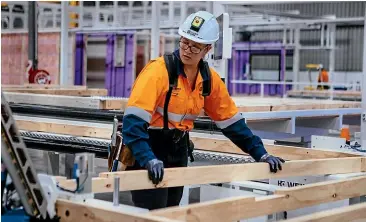  ?? ABIGAIL DOUGHERTY/STUFF ?? Strength is not an issue for workers building homes in the hi-tech Fletcher Building Clever Core factory in Auckland.