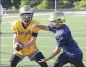  ??  ?? Senior quarterbac­k Landen Haas hands off the ball to senior running back Bryson Duncan.