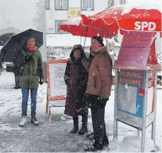  ?? FOTO: HERMANN KÖNIG ?? Im beginnende­n Schneetrei­ben diskutiert die SPD das Thema an ihrem Stand Anfang Januar mit Bürgern.