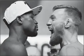  ?? Associated Press ?? Final face off: Floyd Mayweather Jr., left, and Conor McGregor face off during weigh-ins Friday in Las Vegas. The two are scheduled to fight in a boxing match Saturday.