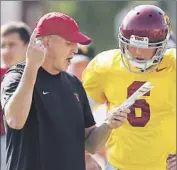  ?? Luis Sinco Los Angeles Times ?? CLAY HELTON WORKS with quarterbac­k Cody Kessler during a USC practice last week. Helton will call the plays against Arizona on Thursday.