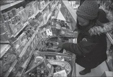  ?? TRIBUNE NEWS SERVICE ?? Sharon Woods rummages through a shopping cart at a Philadelph­ia Walmart Friday. Walmart workers have formed OUR Walmart, which aims to fight for better wages and working conditions.