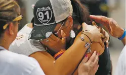 ?? JOHN LOCHER/ASSOCIATED PRESS ?? People embrace survivor Norma Felix at a prayer service Monday on the oneyear anniversar­y of the mass shooting in Las Vegas, Nev. See how she and other survivors marked the anniversar­y on Page A-5.