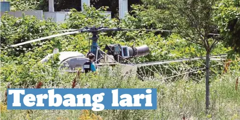  ?? - AFP ?? HELIKOPTER yang ditinggalk­an Faid selepas meloloskan diri dari penjara di Reau.