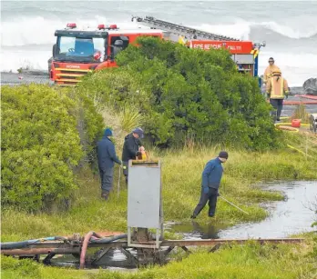  ?? Picture / Gregor Richardson ?? Police searchers scour a small pond at Blackhead Quarry yesterday.