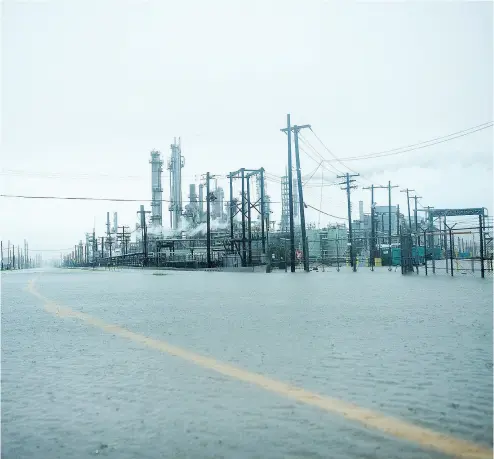  ?? BRENDAN SMIALOWSKI / AFP / GETTY IMAGES ?? The road at the Marathon Texas City Refinery can barely be seen as rain from Hurricane Harvey causes flooding. Genscape refinery analyst Lee Williams said it’s unclear how long oil refineries in Texas will be shut down.