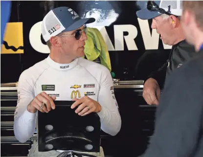  ?? AP ?? Jamie McMurray talks to a crew member in the garage after Saturday’s practice for Sunday’s STP 500 at Martinsvil­le (Va.) Speedway.