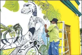  ?? FABIANO MAISONNAVE/AP PHOTO Leticia, in Colombia’s ?? A painter draws a snake in the commercial area of Amazon, on June 15.