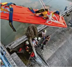  ?? Fotos: Julian Leitenstor­fer ?? Feuerwehrü­bung an der Lechstaust­ufe bei Pitzling: Ein Rettungsbr­ett wird zur Ver letztenret­tung abgeseilt.