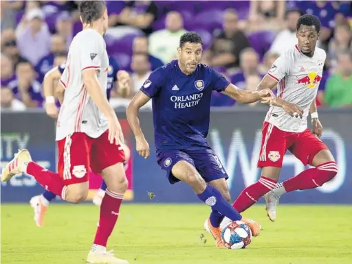  ?? DOUGLAS DEFELICE/USA TODAY SPORTS ?? Orlando City SC’s Tesho Akindele dribbles the ball against the New York Red Bulls on Sunday at Exploria Stadium. “We’ve just been playing game, game, game,” Akindele said.