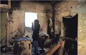  ?? ALLERUZZO/AP MAYA ?? Sharon Alony Cunio surveys the kitchen in the ruins of her home in Kibbutz Nir Oz on Monday. Cunio, her husband and their 3-year-old twin daughters were kidnapped from the home by Hamas militants on Oct. 7. She and her daughters were released in November, but her husband remains in captivity.