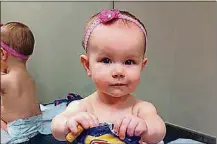  ?? CARRIE STEVENSON ?? Carrie Stevenson’s daughter, Estelle, held a bag of peanut snacks in her pediatrici­an’s office at age 9 months in Columbus, Ohio. Most babies should start eating peanut-containing foods well before their first birthday, say the National Institutes of Health guidelines that aim to protect high-risk tots and other youngsters, too, from developing the dangerous food allergy. The guidelines are a shift in dietary advice, based on landmark research that found early exposure dramatical­ly lowers a baby’s chances of becoming allergic.